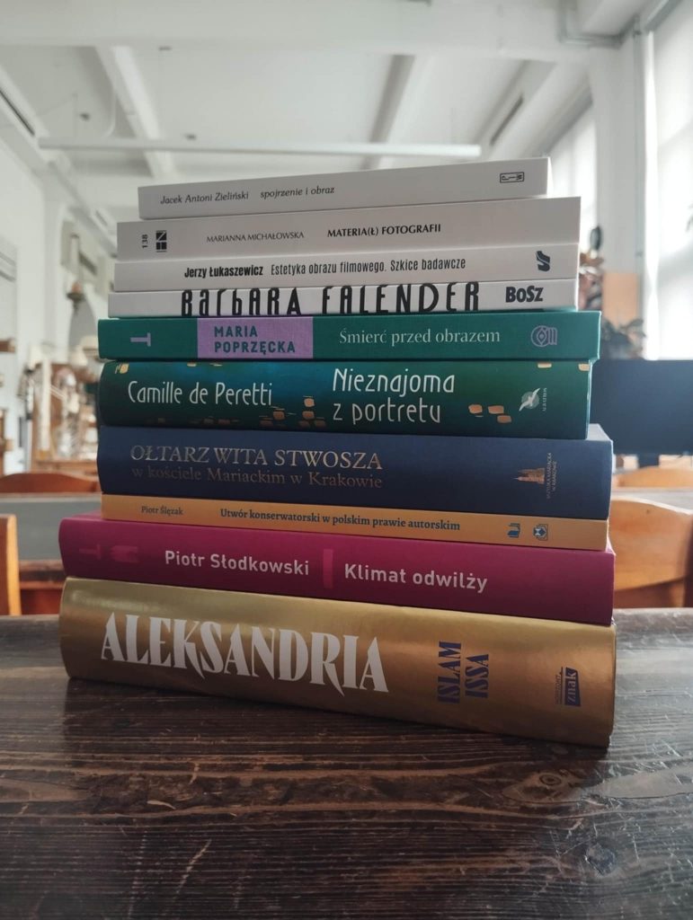 Sterta 10ciu książek na tle czytelni bibliotecznej